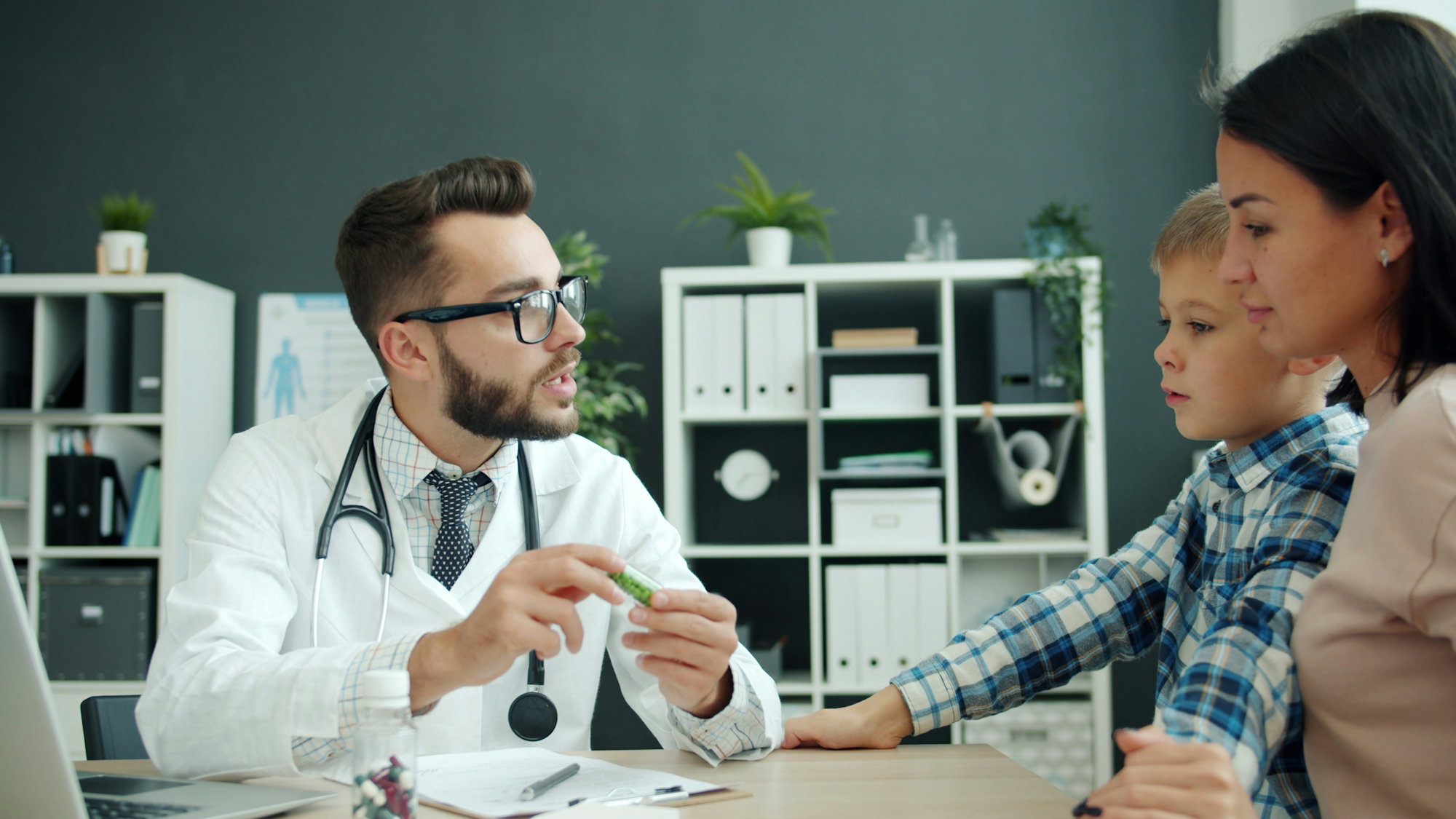 doctor-talks-to-mother-and-son-in-office-.jpg Doctor talks to mother and son in office.